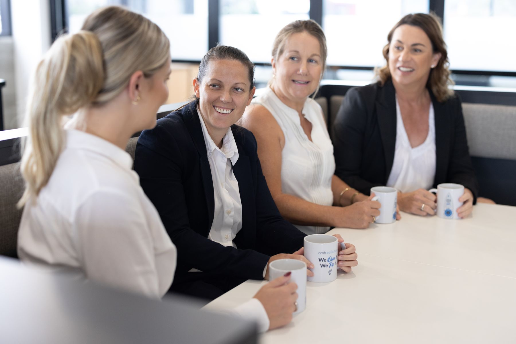 Members of the OMB team talking over coffee in the Southport office